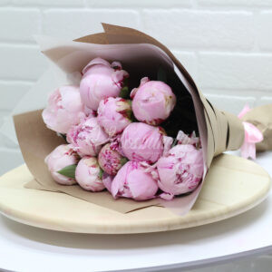 Букет из 11 розовых пионов в крафте