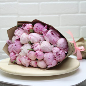 Букет из 21 розовых пионов в крафте