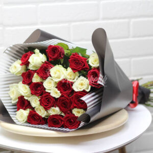 букет из 31 красных и белых роз в дизайнерской упаковке